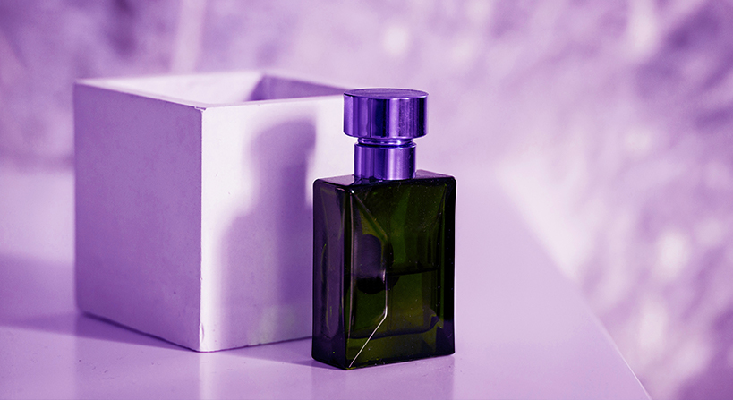 Elegant perfume bottle design with purple cap and box on a purple background