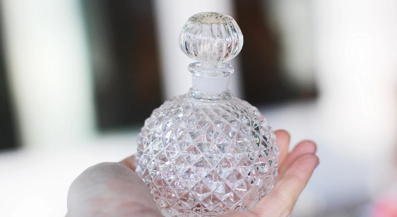Elegant lead crystal glass perfume bottle reflecting light for luxury fragrance