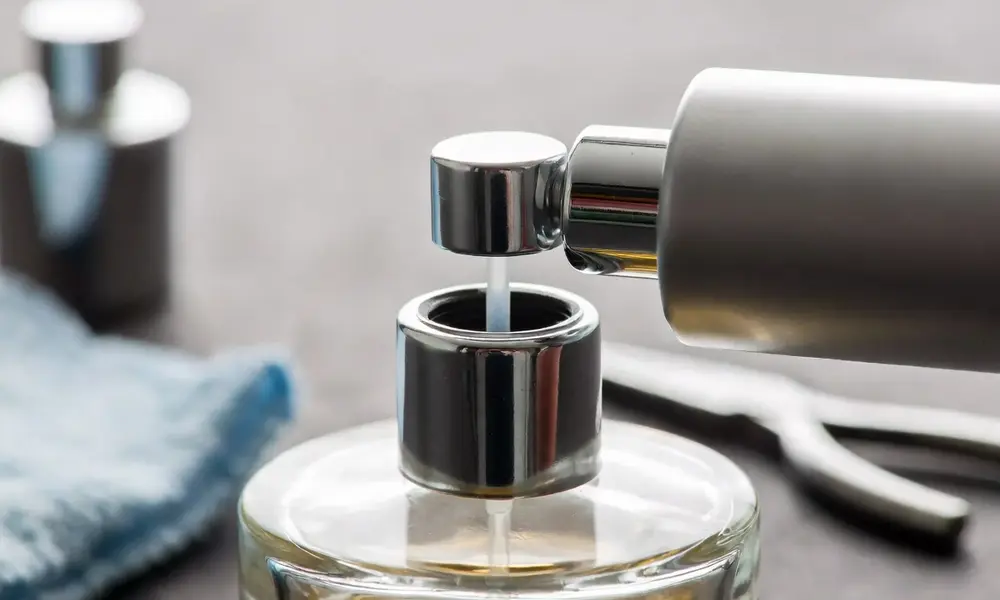 New perfume sprayer being screwed onto a glass bottle with exposed dip tube